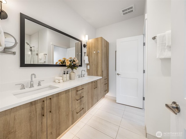 bathroom with tile patterned floors, double vanity, and a shower