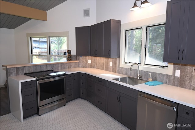 kitchen featuring lofted ceiling with beams, a sink, appliances with stainless steel finishes, and light countertops