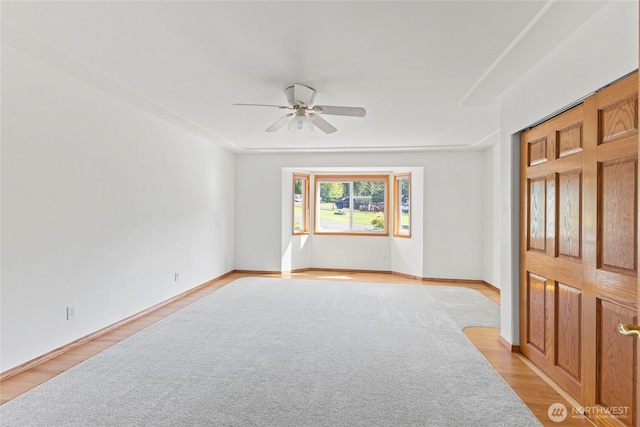 empty room with ceiling fan and light wood-style floors