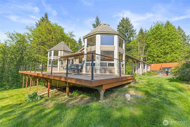 rear view of property featuring a wooden deck and a yard