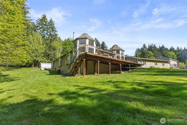 back of property featuring stairway, a yard, and a deck