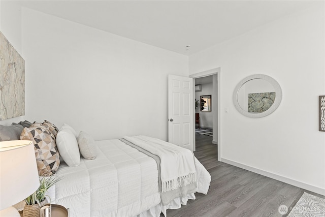 bedroom with baseboards and wood finished floors