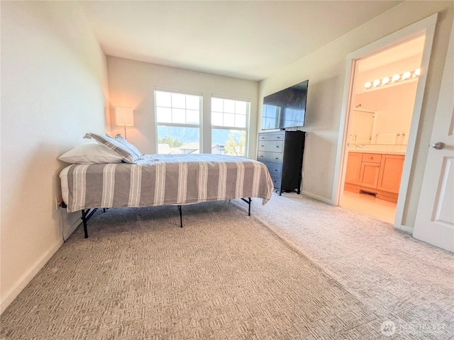 carpeted bedroom featuring visible vents, connected bathroom, and baseboards