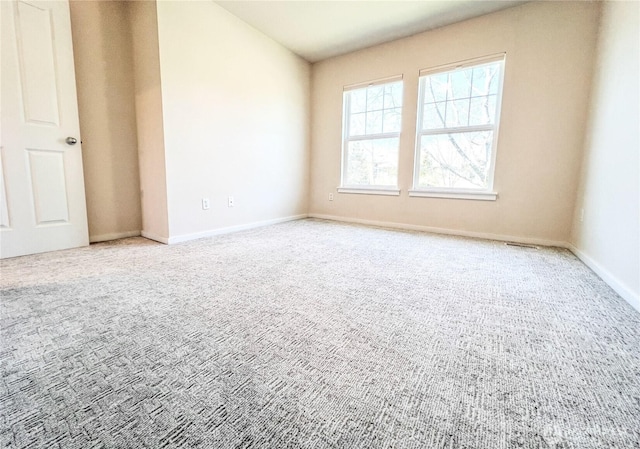spare room featuring baseboards and light colored carpet