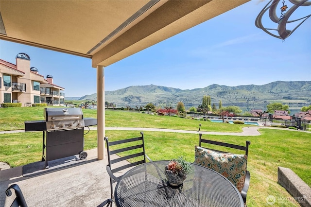 view of patio with a mountain view, area for grilling, and outdoor dining space