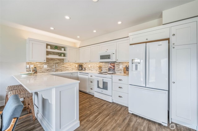 kitchen featuring white appliances, open shelves, white cabinets, and a peninsula
