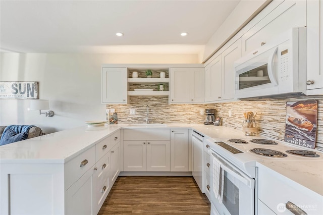 kitchen featuring decorative backsplash, open shelves, a sink, white appliances, and a peninsula