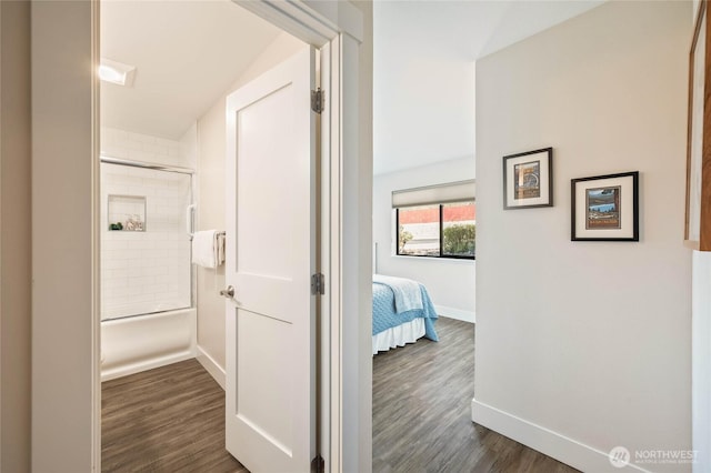 hall featuring baseboards and dark wood-type flooring