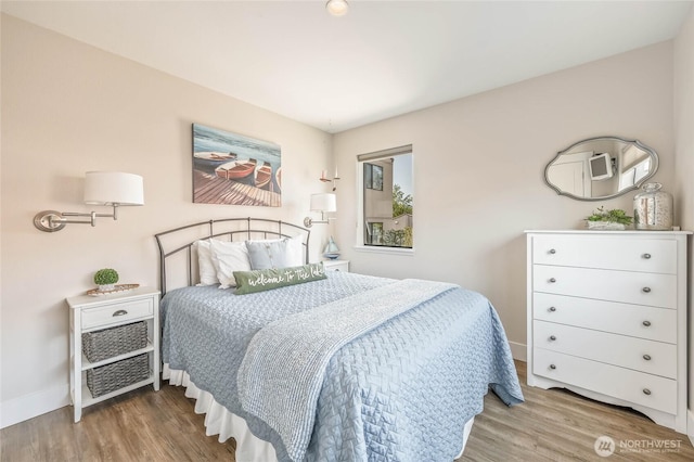 bedroom with wood finished floors and baseboards