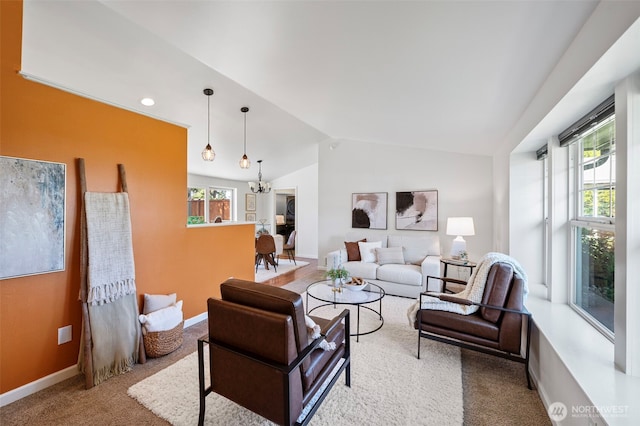 living room with an inviting chandelier, baseboards, carpet floors, and lofted ceiling