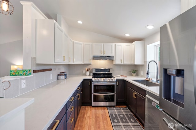 kitchen featuring light countertops, a sink, white cabinetry, and stainless steel appliances