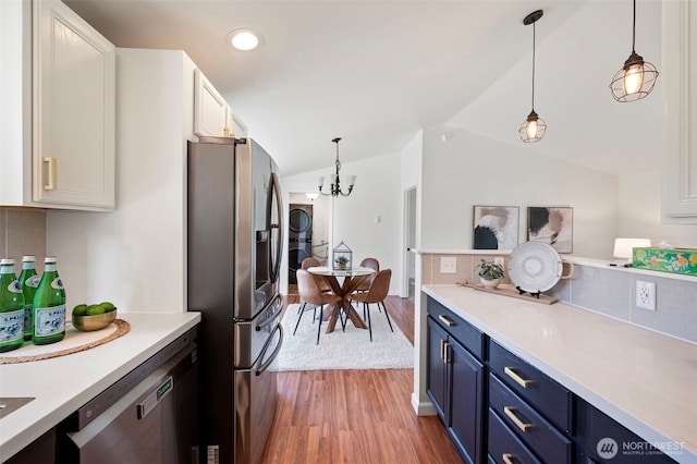kitchen featuring light countertops, stainless steel appliances, blue cabinets, and wood finished floors