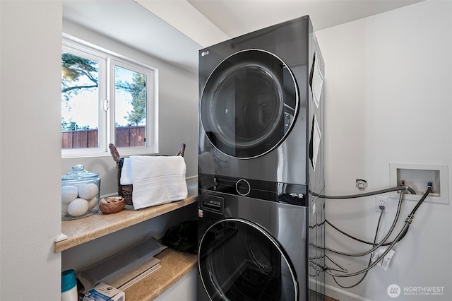 laundry area featuring stacked washer / drying machine and laundry area