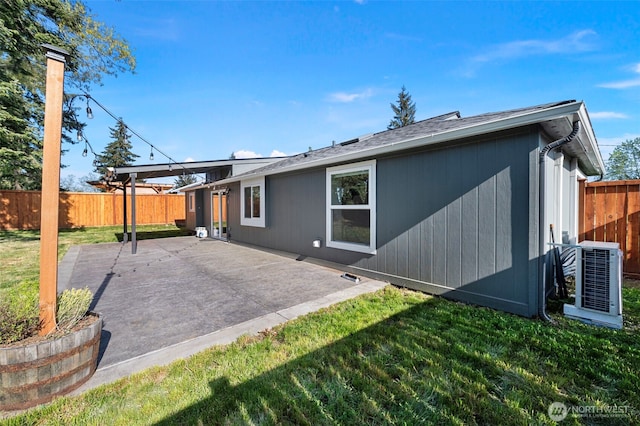 back of house with a patio, central AC unit, a fenced backyard, and a yard