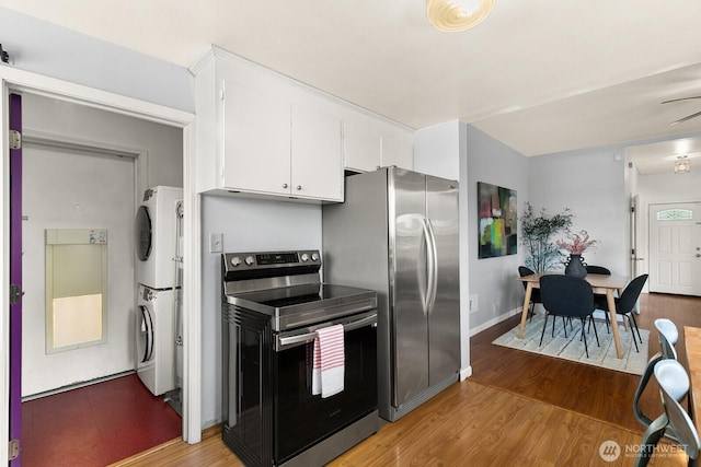 6357 37th Ave SW, Seattle, WA 98126 - kitchen featuring stainless steel appliances, stacked washer and clothes dryer, white cabinets, light wood-type flooring, and ceiling fan