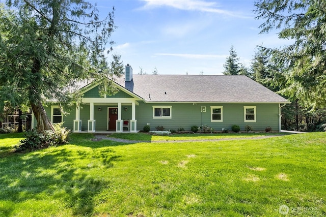 back of house featuring a chimney, a yard, and a porch