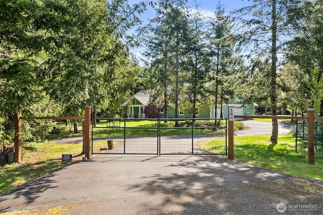 view of gate featuring fence and a yard
