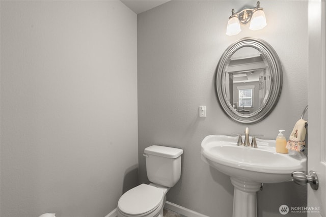 bathroom featuring baseboards and toilet