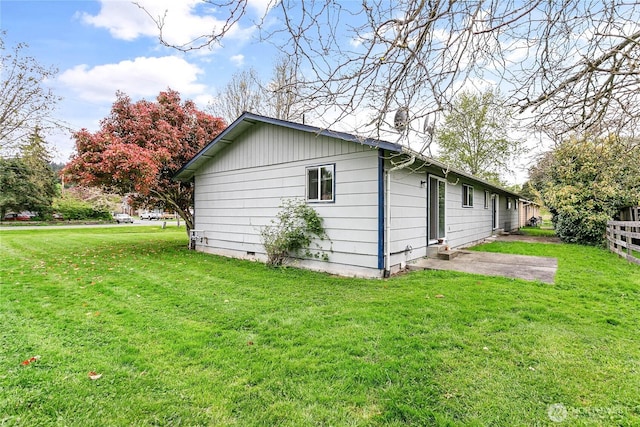 view of home's exterior featuring a lawn and fence
