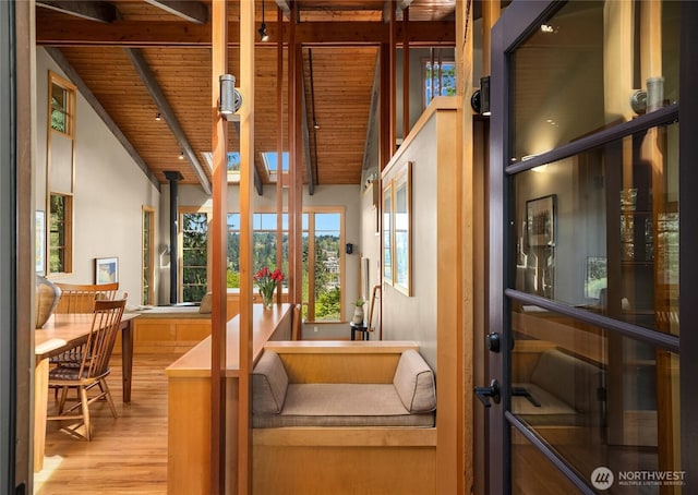 interior space featuring wood finished floors, a healthy amount of sunlight, wooden ceiling, and beamed ceiling