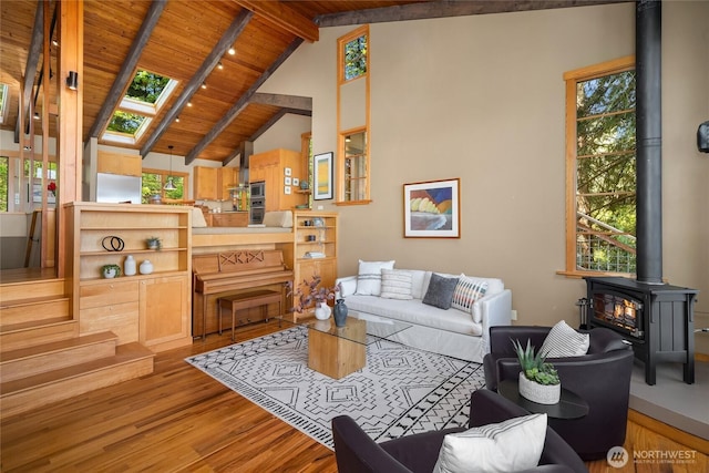 living room featuring a wood stove, wood ceiling, and wood finished floors