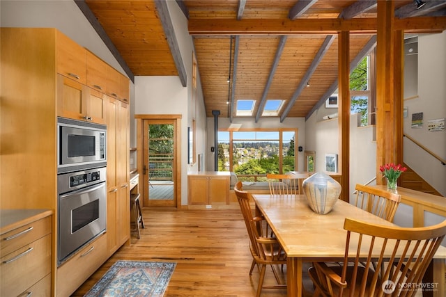 kitchen featuring light wood-style floors, wood ceiling, beam ceiling, and stainless steel appliances
