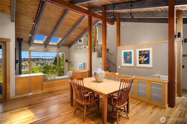 dining area featuring wooden ceiling, beamed ceiling, and light wood finished floors