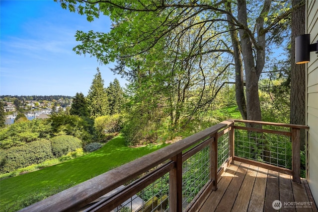 wooden terrace featuring a water view and a yard