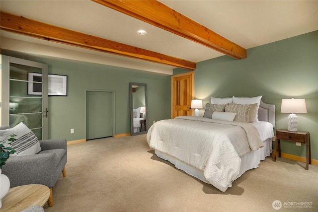 bedroom featuring baseboards, beamed ceiling, and light carpet