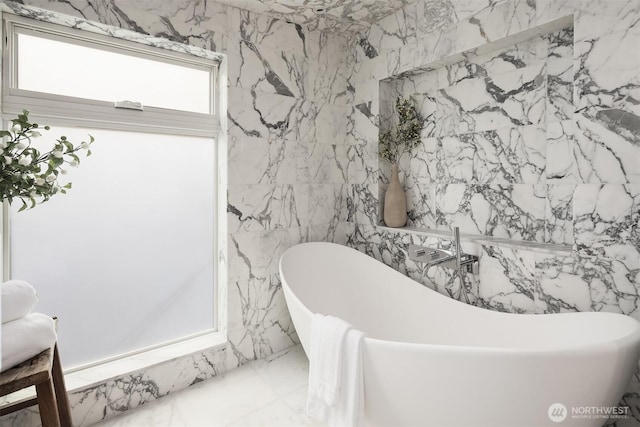 bathroom featuring tile walls and a soaking tub