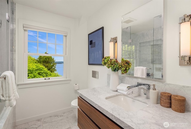 full bathroom with vanity, marble finish floor, toilet, baseboards, and a stall shower