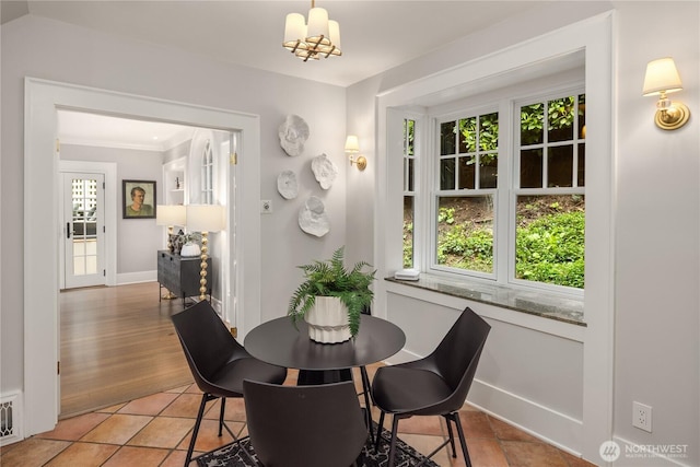 dining space with baseboards, crown molding, light tile patterned floors, and a healthy amount of sunlight