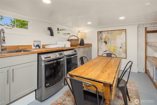 laundry room featuring recessed lighting, laundry area, washer and clothes dryer, and a sink
