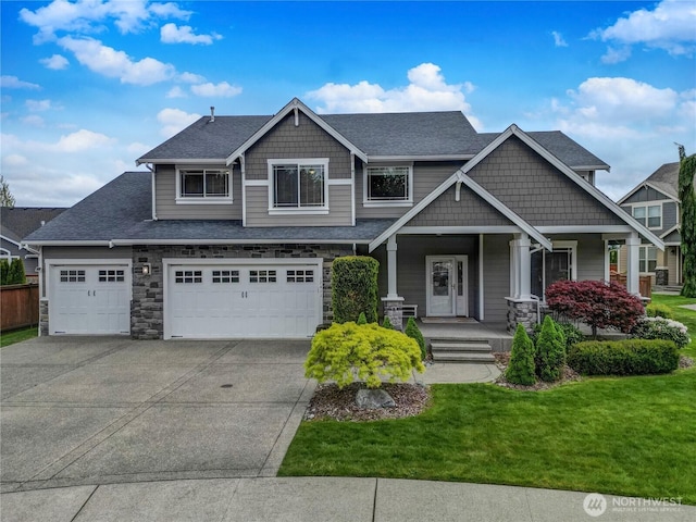 craftsman-style home featuring a porch, driveway, a garage, a front lawn, and stone siding