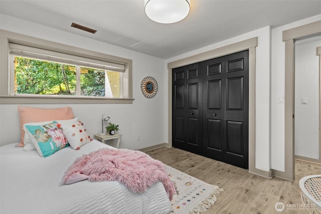 2716 58th Street Ct NW, Gig Harbor, WA 98335 - bedroom with baseboards, a closet, light wood-type flooring, and visible vents