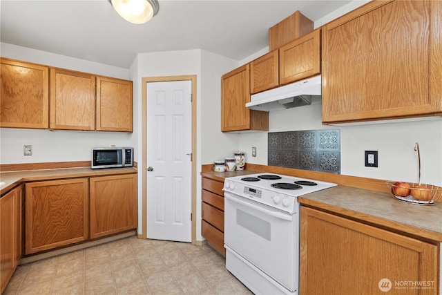 926 99th St SW, Everett, WA 98204 - kitchen featuring stainless steel microwave, white electric stove, under cabinet range hood, brown cabinetry, and light countertops