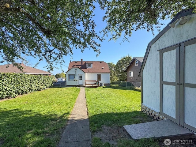 view of yard with an outdoor structure, a storage shed, and fence