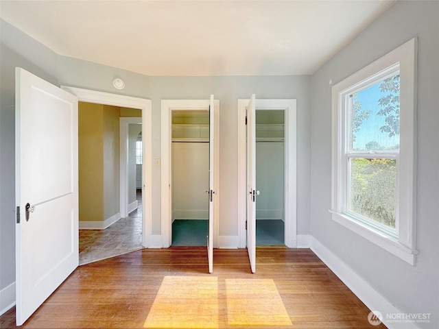 unfurnished bedroom with baseboards and light wood-style flooring