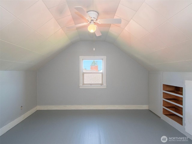 additional living space featuring baseboards, lofted ceiling, and a ceiling fan