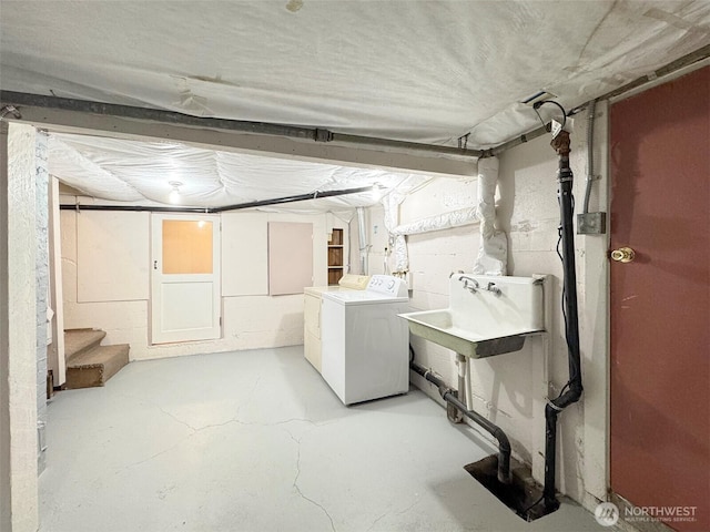 unfinished basement with washer and clothes dryer, stairway, and a sink