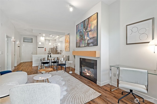 521 7th Ave Unit 204, Kirkland, WA 98033 - living area with wood finished floors, a glass covered fireplace, and baseboards
