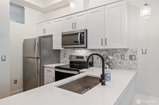 521 7th Ave Unit 204, Kirkland, WA 98033 - kitchen with stainless steel appliances, a sink, decorative backsplash, white cabinets, and decorative light fixtures