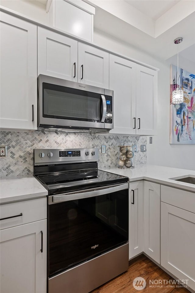 521 7th Ave Unit 204, Kirkland, WA 98033 - kitchen featuring appliances with stainless steel finishes, light countertops, white cabinets, and backsplash