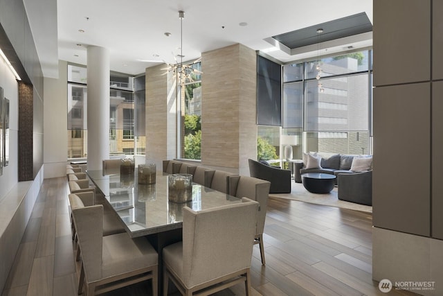 10610 NE 9th Pl Unit G403, Bellevue, WA 98004 - dining space with a chandelier, wood finished floors, a wall of windows, and ornate columns