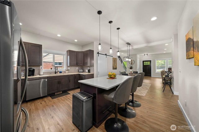 3315 N 35th St, Tacoma, WA 98407 - kitchen featuring dark brown cabinetry, appliances with stainless steel finishes, a barn door, a sink, and open floor plan