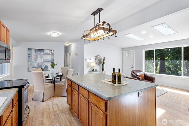 kitchen featuring light wood-style floors, open floor plan, a center island, and stainless steel appliances