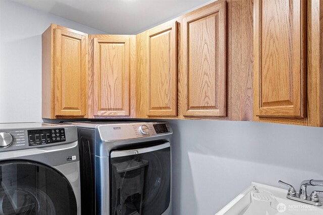 laundry area featuring washer and clothes dryer and cabinet space