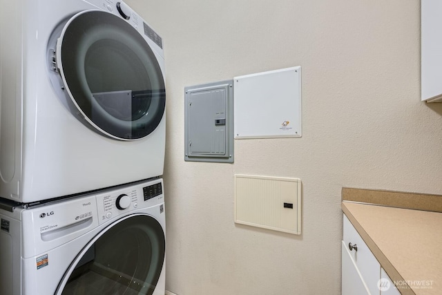 320 E 32nd St Unit 105, Tacoma, WA 98404 - laundry area featuring cabinet space, stacked washing maching and dryer, and electric panel
