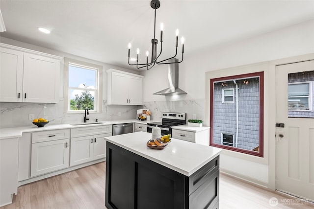 1538 7th St, Bremerton, WA 98337 - kitchen featuring wall chimney range hood, appliances with stainless steel finishes, a sink, and light wood-style floors