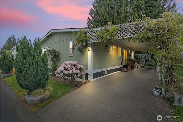 607 37th St SE Unit 92, Auburn, WA 98002 - property exterior at dusk featuring driveway, an attached carport, crawl space, and entry steps